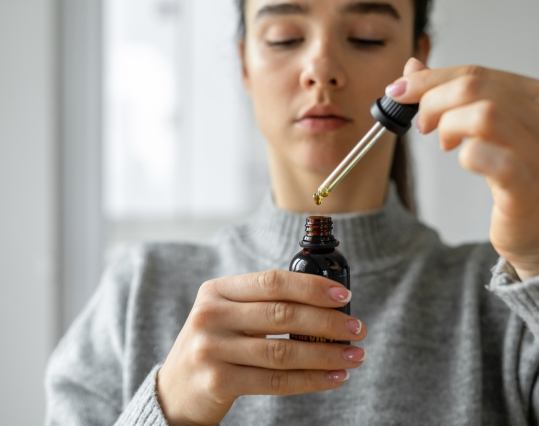 Woman opening a bottle of CBD oil