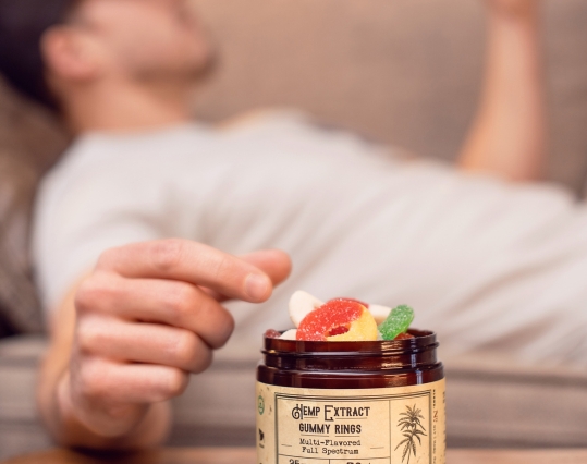 Man reaching for a tub of CBD gummies